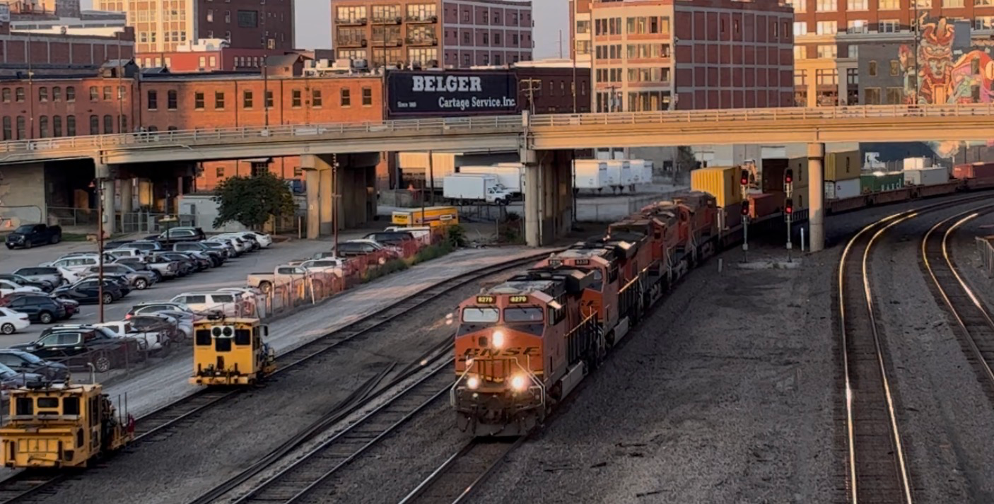 Long BNSF intermodal train moving fast under the pedestrian bridge